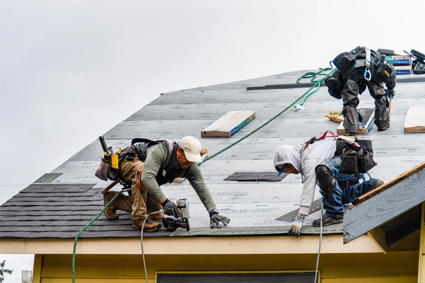 Roofers installing architectural shingles on a home